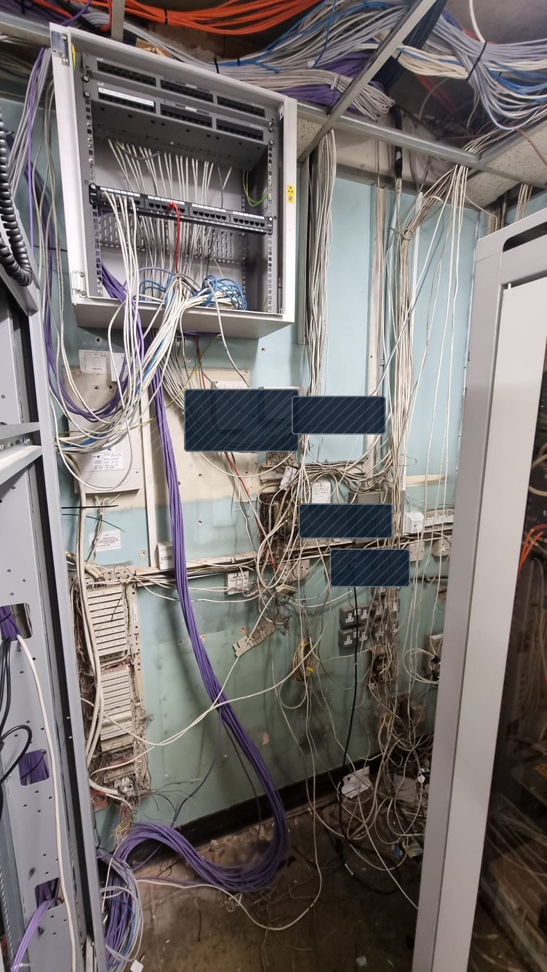 Legacy comms room wall cabling before strip out